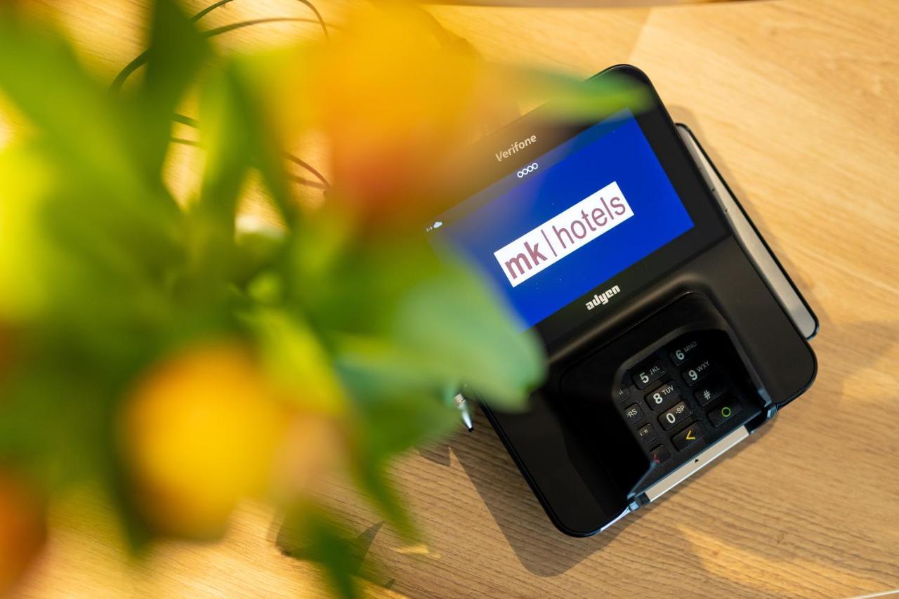 Rinas Mk Hotel Tirana מראה חיצוני תמונה A mobile phone with the MK1Hotels logo on the screen
